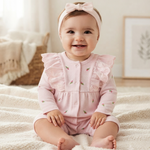 A romper in soft pink, decorated with small floral embroidery and elegant ruffles on the sleeves 17274